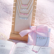 Faith-inspired necklaces from AMADI Jewelry’s ‘He Says That I Am’ collection. Identity in Christ jewelry for Christian women, inspired by Ephesians 1:3-13. Gold-plated and enamel pendants.
