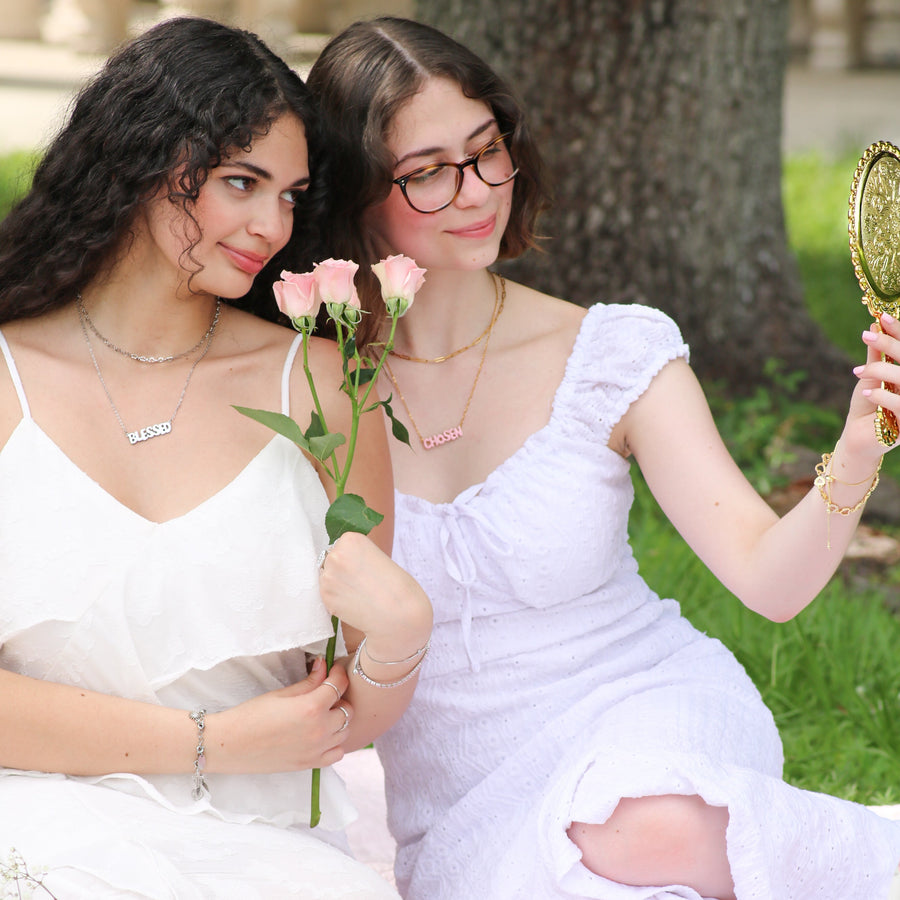 Christian jewelry collection with faith-based necklaces featuring words like blessed, loved, redeemed, and chosen. Minimal gold and enamel pieces designed for Christian women to express their identity in Christ. Inspirational Bible verse jewelry from Ephesians 1 by AMADI Jewelry.