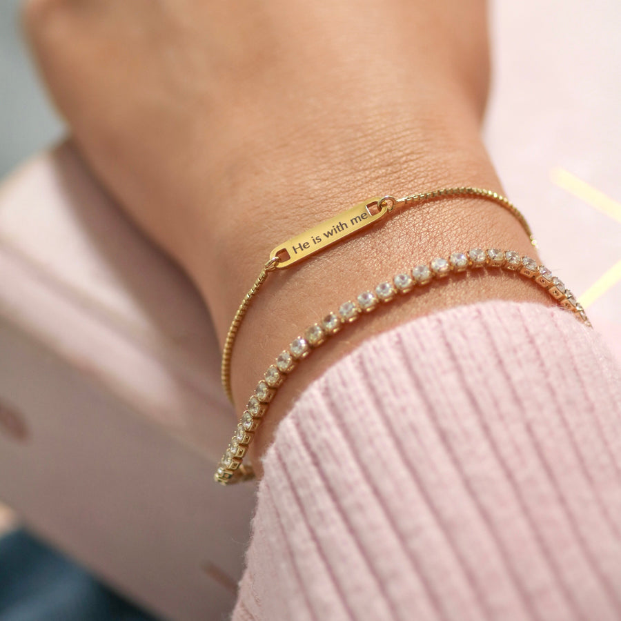 Close-up of a hand wearing multiple bracelets on a light background